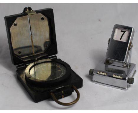 		A Bakelite military marching compass. T.G. Co Ltd Mark I together with a chromium plated desk calendar. C.R. Compass good