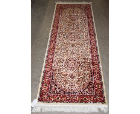 		A beige ground Keshan runner. 210cm x 70cm