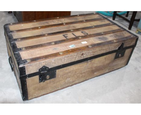 		A canvas and wool bound cabin trunk containing an umbrella and magazines