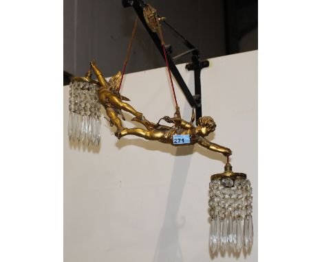 		A gilt spettar hanging lamp formed as a pair of winged putti bearing the prismatic cut lustre drops. 18' wide