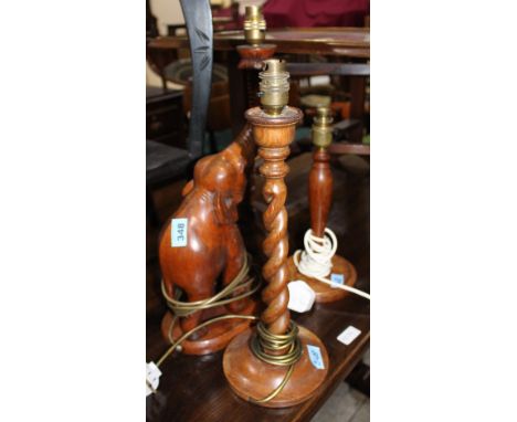 		A carved elephant table lamp and two other treen lamps