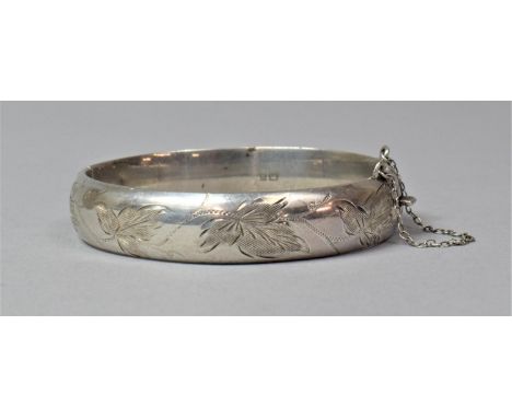 A Sterling Silver Bangle with Safety Chain and Engraved Floral Decoration 