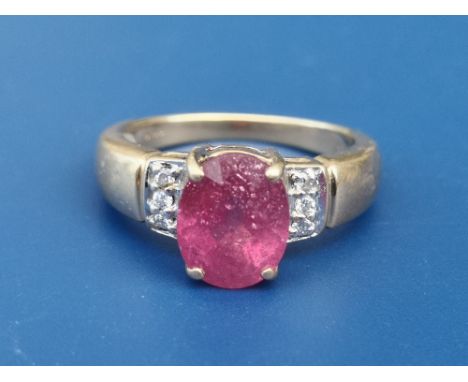 A ruby &amp; diamond set 18ct gold ring, having oval four-claw set ruby above small diamonds to shoulders.  Finger size N.