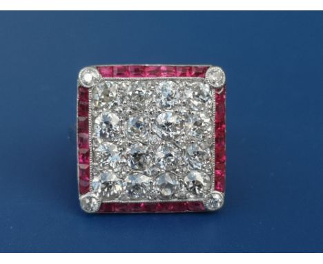 An Edwardian diamond &amp; ruby set platinum panel ring, of square design, having four rows of old cut diamonds within a bord