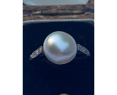 A certified natural saltwater pearl ring, the button-shaped pearl 10.3mm, of cream colour with good lustre, flanked by six sm