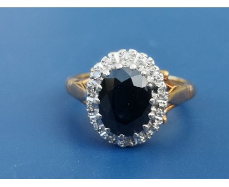 An oval sapphire &amp; diamond 18ct gold cluster ring.  Finger size K.