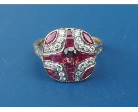 A ruby &amp; diamond set 18ct gold panel ring, having a cruciform design of calibre set rubies to centre.  Finger size M.