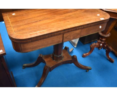 A 19th Century fold over card table on platform base with quatrefoil legs and brass castors, having brass inlay line decorati