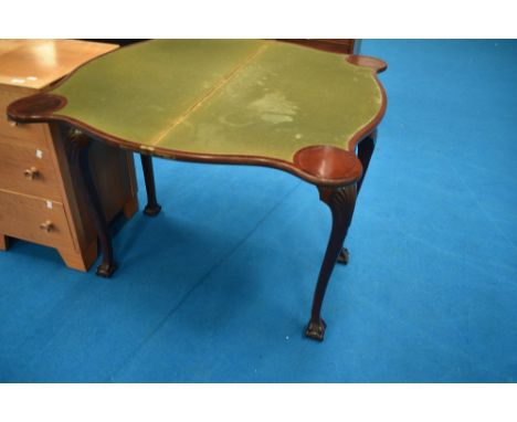 A late 19th or early 20th Century mahogany fold over card table having shaped top and legs, having ball and claw feet