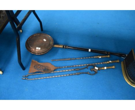 A traditional copper warming pan and selection of fire tools