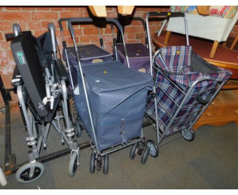 A folding wheelchair and four folding shopping trolleys.