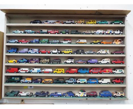 Diecast Models - a wall mounted wooden display case containing approx 77 diecast model motor vehicles to include Corgi Junior