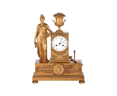 A French Empire gilt-metal mantel clock, the case with a campana vase, spade and rake (now loose), and a Classical figure hol