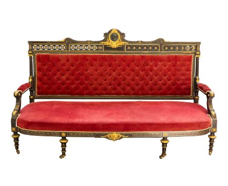 A French Napoleon III ebonised canape or settee, with ormolu mounts, the lattice top rail surmounted by a Classical profile p
