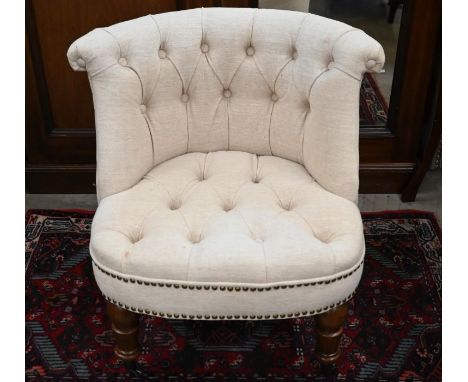 An Oka style chair with cream button-back upholstery and turned front legs with castors