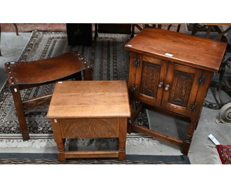 A small carved oak two-door cabinet, 50 cm w x 33 cm d x 69 cm h to/w a carved oak stool with studded leather seat and carved