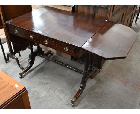 A Regency mahogany and ebony strung sofa table with two drawers opposed by dummy drawers, spiral reeded supports and shaped l