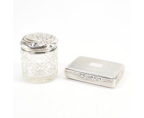 A silver hallmarked pill pot having empty cartouche to centre with engine turned decoration upon lid. the lip having scrolled