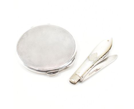 A hallmarked silver compact mirror having circular form having engine turned decoration to to outer case. Assay marked for Bi