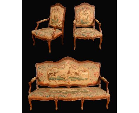 A Louis XV Revival three piece suite, comprising a sofa and a pair of armchairs, carved throughout with flowerheads and scrol