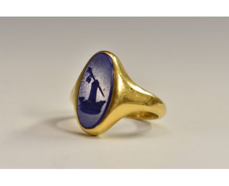 A George V 18ct gold lapis lazuli seal stamp ring, oval lapis lazuli panel carved with, a mace held aloft by and armored glov