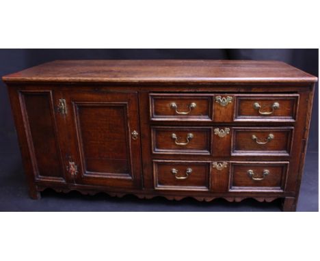 An 18th century oak side chest, oversailing top, fitted with three long block fronted drawers flanked by a fielded panelled c