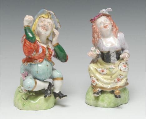 A rare pair of Bloor Derby figures, of Grimacing Dwarfs, each grotesque modelled sitting on a grassy mound, each enamelled in