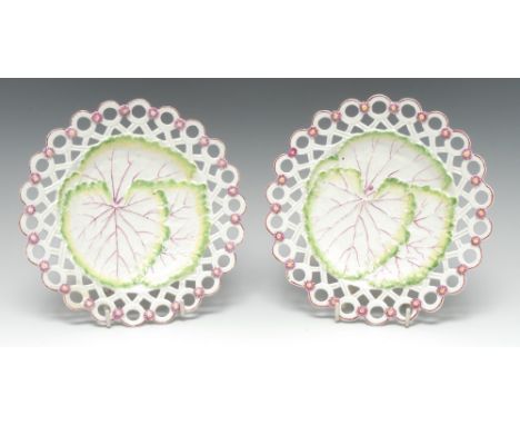 A pair of early Derby leaf-moulded 'spectacle' plates, picked out in tones of green, sallow and puce, the pierced borders mou