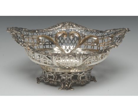 A Victorian silver shaped oval bread basket, the pierced border embossed with ribbon-crested beaded portrait roundels and lea