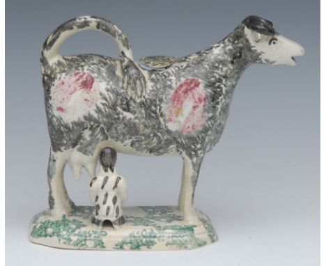 A 19th century Staffordshire cow creamer, standing four square, painted black, puce patch markings, with milkmaid, sponged ca