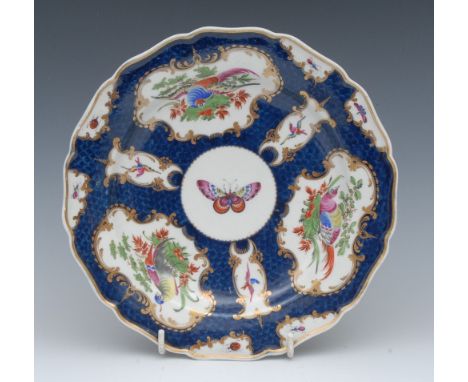 A  Worcester shaped circular plate, decorated with fan and vase shaped reserves with fanciful birds on a scale blue ground, g