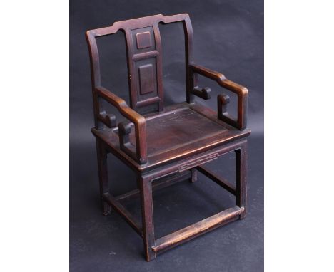 A Chinese hardwood armchair, rectangular splat with two raised panels, scroll arms, carved front rail, rectangular stretchers