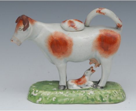 A Staffordshire cow creamer, standing four square, with calf, rust patch markings, rounded rectangular base, 13cm wide, c.184