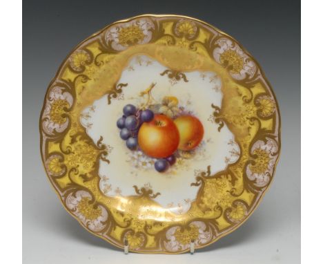 A Royal Worcester shaped circular cabinet plate, painted by John Freeman, signed, with ripe apples and grapes on a mound of h