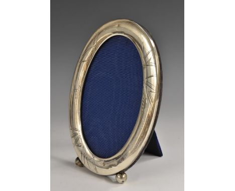A Chinese silver oval easel photograph frame, engraved with leafy bamboo, ball feet, 17.5cm high, character mark