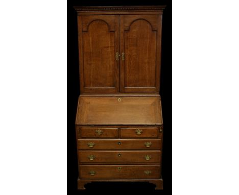 An 18th century oak bureau bookcase, dentil cornice, two arched panel doors to top, the fall front enclosing fitted interior,