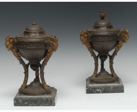A pair of Neo-Classical Revival patinated and parcel-gilt metal tripod mantel vases and covers, knop finials, caprine monopod