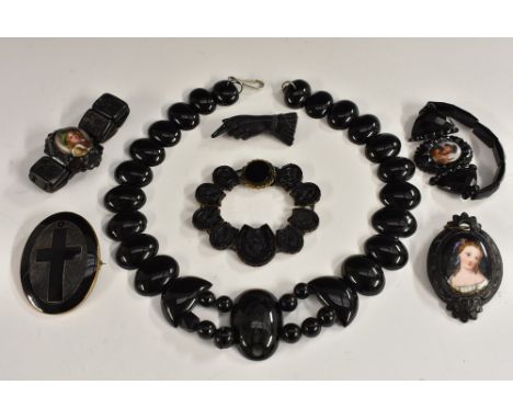 Jewellery - a Victorian jet and porcelain portrait brooch, maiden; others carved hand; cross; a similar horseshoe panel brace