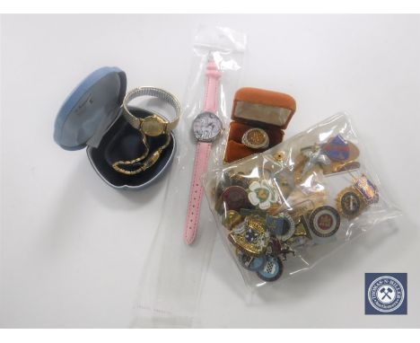 A box containing a quantity of enamel badges, silver gilt ring, lady's wristwatches 
