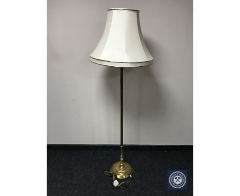 A brass standard lamp with shade