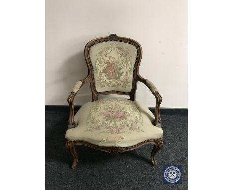 A continental walnut framed salon armchair upholstered in a tapestry fabric
