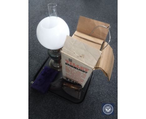 A tray of Duplex oil lamp, Tilley lamp, two flat irons and a set of cased miniature balance scales with weights 