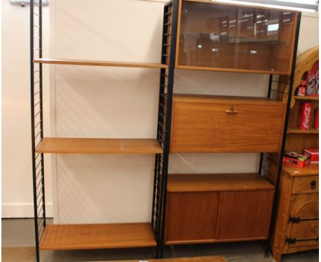 A Ladderax unit, the upper section enclosed by glazed sliding doors above a drop front writing cabinet and cupboard below enc