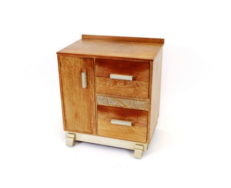 A 1930's limed oak and gilt decorated linen cabinet, interior shelf enclosed by a single door flanked by drawers, 70cm wide