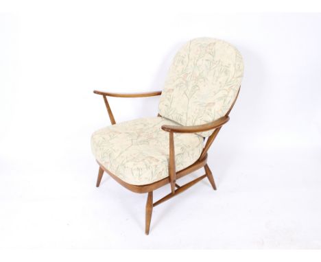 An Ercol armchair, the seat and back cushion upholstered in floral tapestry