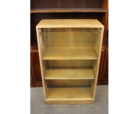 A pair of light oak "Good Furniture Units" bookcases, the adjustable shelves enclosed by glazed sliding doors, 68cm wide x 11