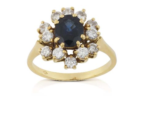 the oval cut sapphire within an undulating border of round brilliant cut diamonds, in yellow claw settings, to a tapered shou