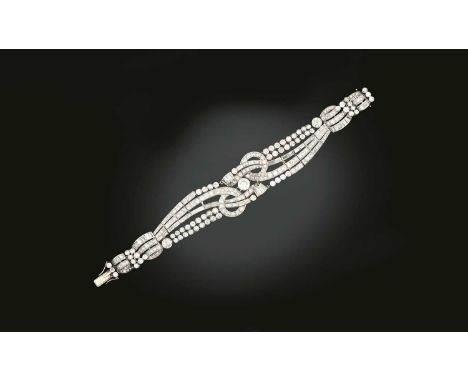 the scroll motifs set throughout with round brilliant and baguette cut diamonds, in white claw and rubbed over settings, tota