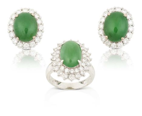 the oval cabochon jade within a double stepped border of round brilliant cut diamonds, in white claw settings, to a tapered s