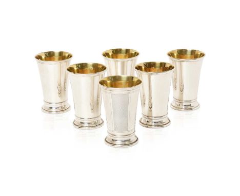 each tapering cylindrical and on spreading foot, one with three bands of engine-turned decoration, the interiors gilt12cm hig
